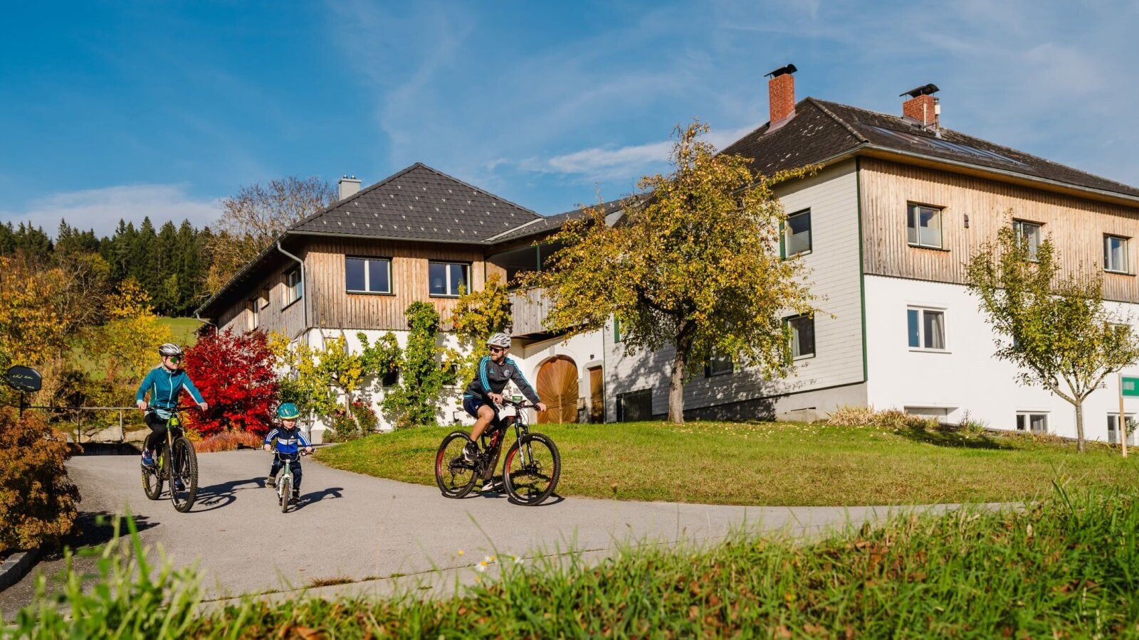 The Bauernhof with guests cycling on the path, ideal for outdoor activities in nature.
