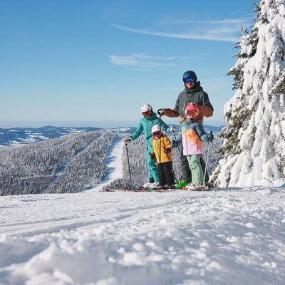 Family skiing in the snowy mountain landscape, one of the winter activities you can experience from the farmhouse.