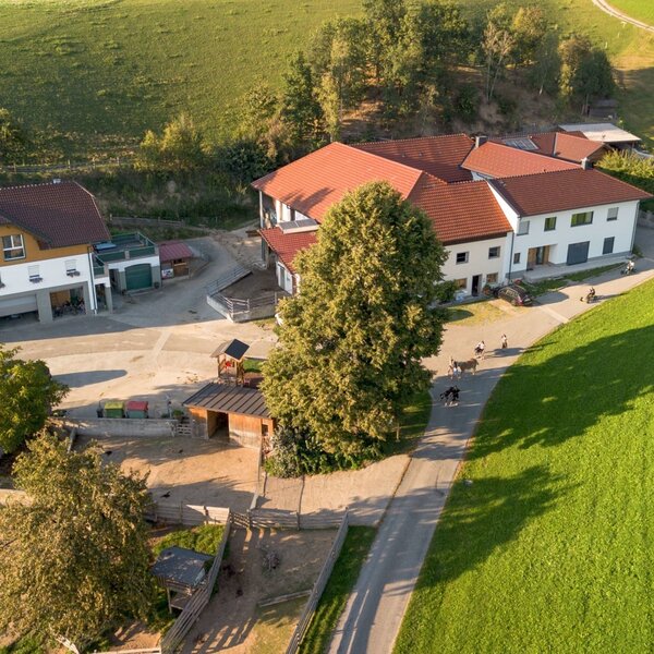 Aerial view of the farmhouse, surrounded by green fields