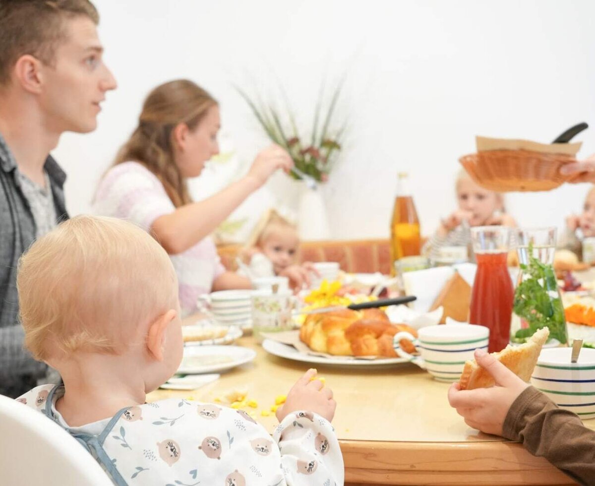 A cozy family breakfast at a richly set table on the farmhouse.
