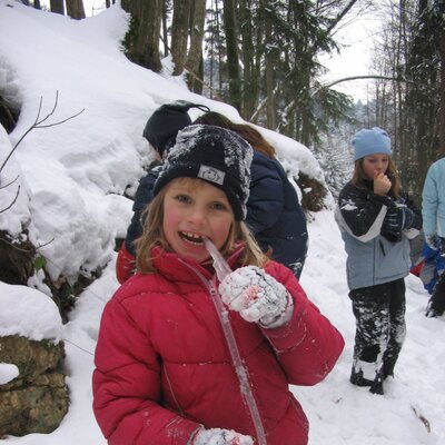 Children playing in the snow in the wooded environment surrounding the Farm House.