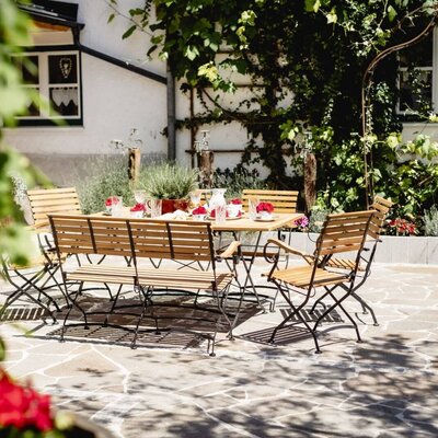 The terrace of the Appartements, featuring a set wooden table and seating for outdoor dining or relaxation.