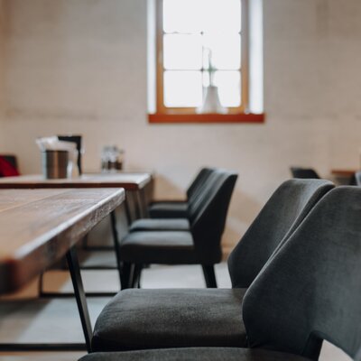 The farmhouse dining room features wooden tables, upholstered chairs, and natural light from the windows.