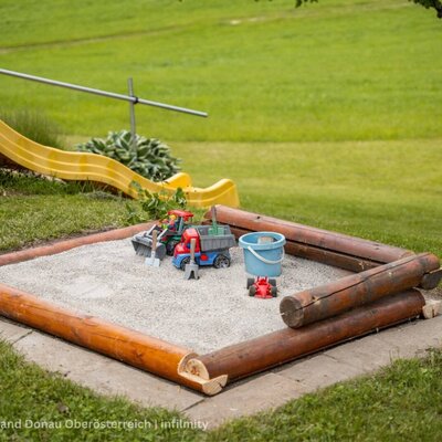 Sandbox with toys and a slide