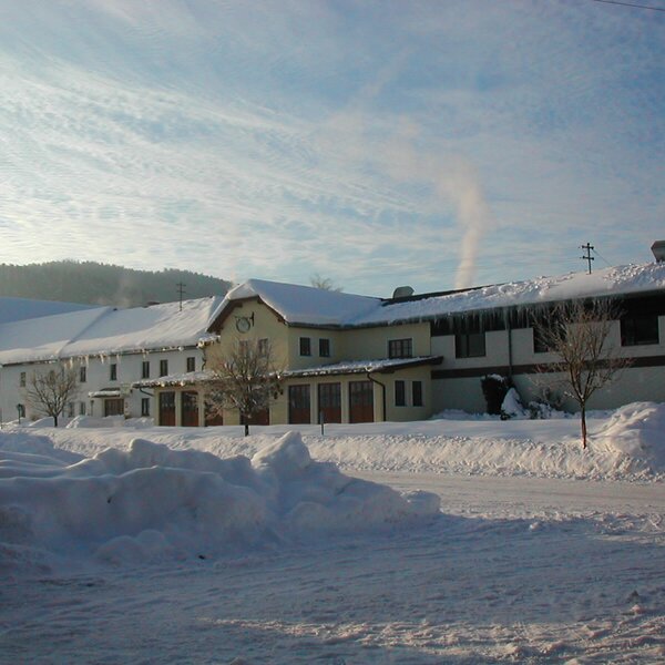 The Farm House exterior in winter, featuring snow-covered roofs, icicles, and a snowy ground. The Farm House exterior in winter, featuring snow-covered roofs, icicles, and a snowy ground.