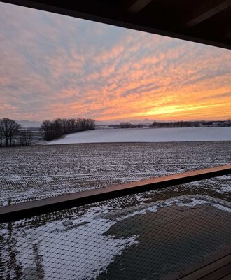 Sunset over the snowy landscape, viewed from the holiday home's balcony with a safety net.