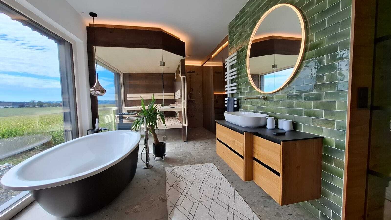 The holiday home's luxurious bathroom featuring a freestanding bathtub, a private sauna, and scenic countryside views.