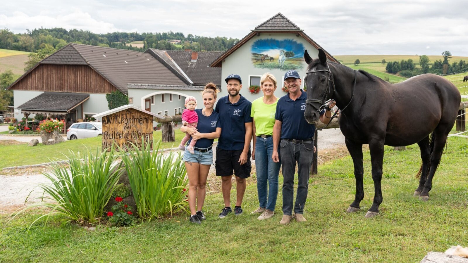 The welcoming host family greets you at their idyllic farmhouse, complete with horses and lush green pastures.