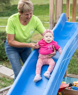 The farmhouse's inviting playground featuring a blue slide for little guests to enjoy.