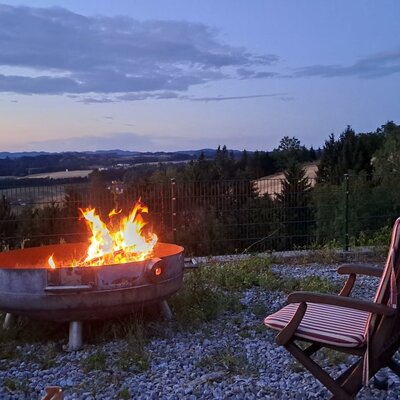 An inviting fire pit with cozy seating and scenic views over the rolling hills at dusk.