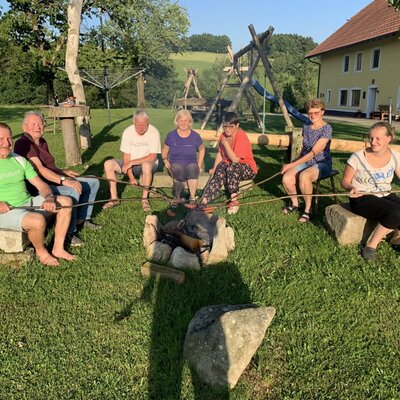 An inviting campfire area on the farmhouse's spacious green lawn, perfect for cozy outdoor gatherings.