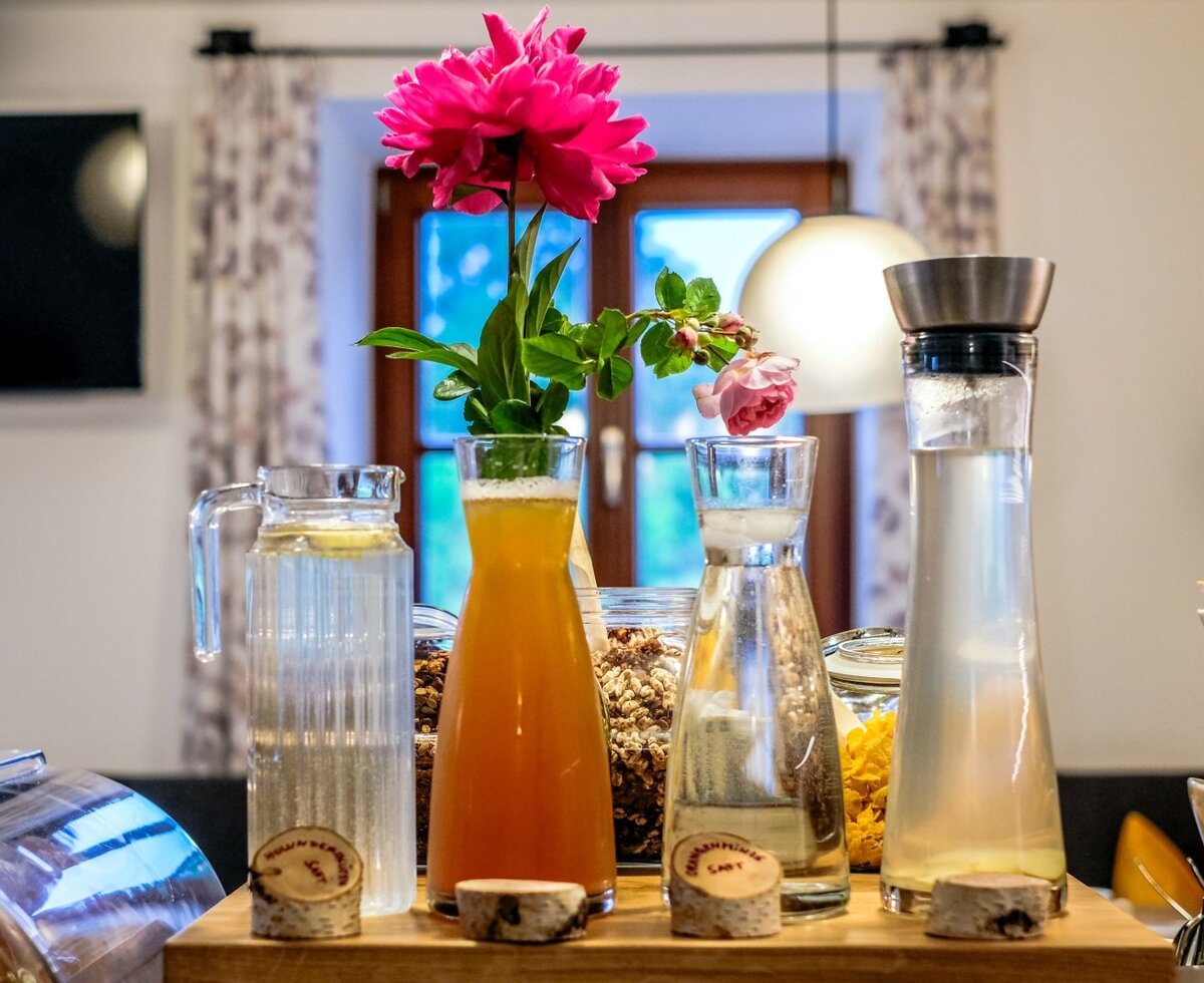 Breakfast buffet at the farmhouse, featuring various drinks in carafes and cereals in jars.
