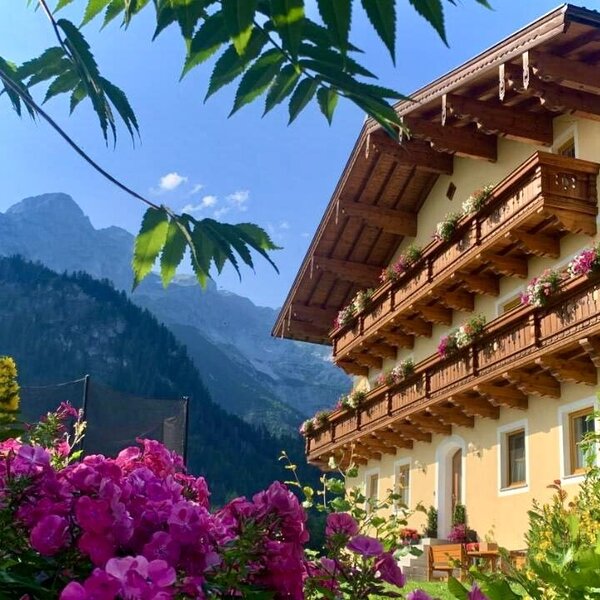 Exterior view of the farmhouse with seating in front of and next to the house.