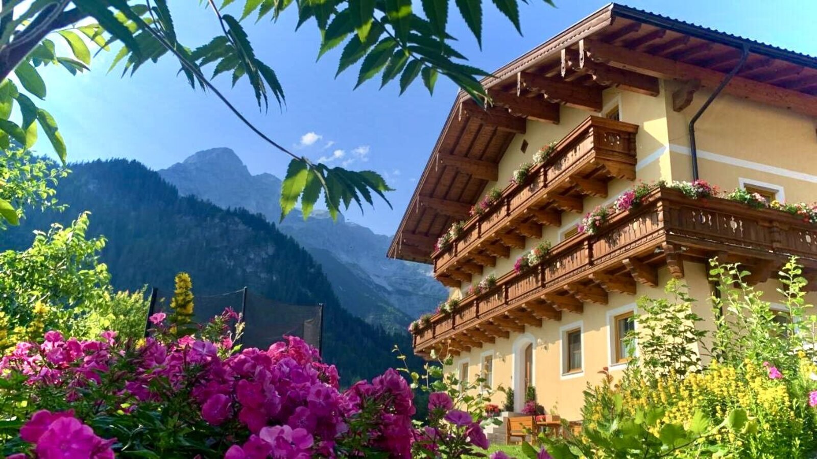 Exterior view of the farmhouse with seating in front of and next to the house.