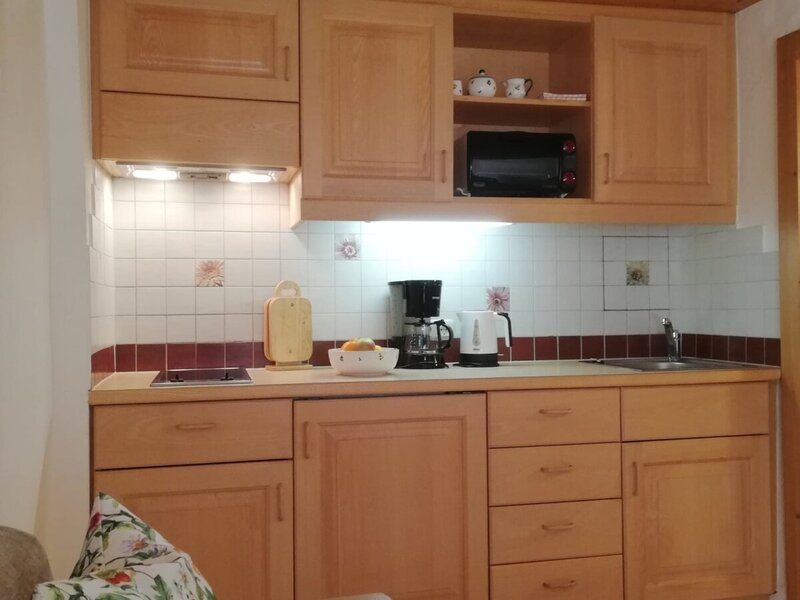 The farmhouse kitchenette includes wooden cabinetry, an electric hob, microwave, coffee maker, kettle, and sink.