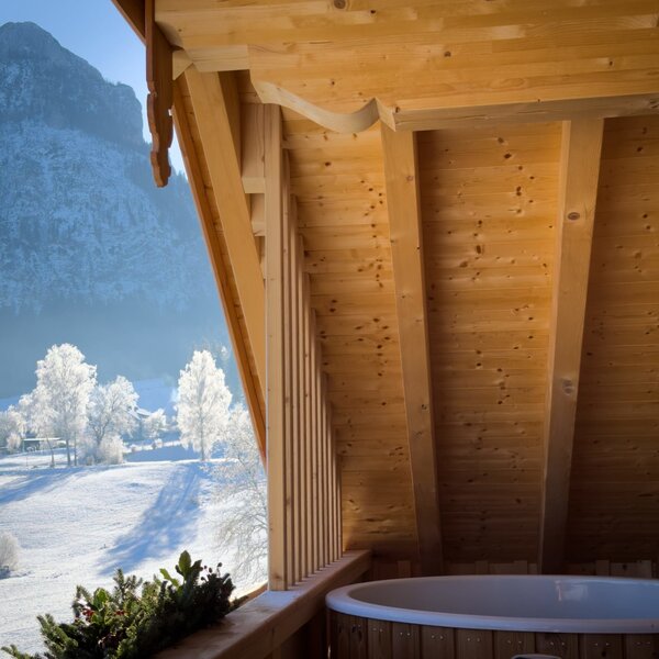 Balcony at the Farm House with an outdoor hot tub, offering a view of the snow-covered mountains and winter landscape. Balcony at the Farm House with an outdoor hot tub, offering a view of the snow-covered mountains and winter landscape.