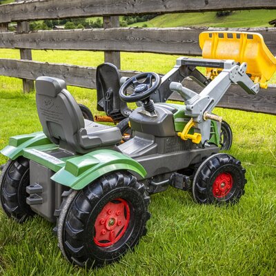 Fun pedal tractors for children on the farmhouse's green lawn.