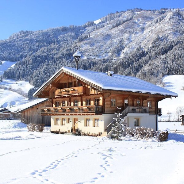 The Farm House exterior in winter, featuring a wooden facade, balconies, and a snow-covered roof, set against a mountainous landscape. The Farm House exterior in winter, featuring a wooden facade, balconies, and a snow-covered roof, set against a mountainous landscape.