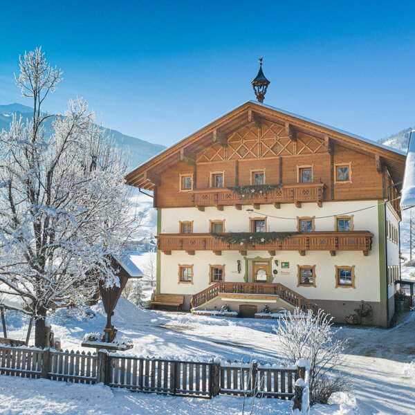 The Farm House exterior in winter, featuring traditional wooden balconies and a snow-covered landscape extending to the mountains. The Farm House exterior in winter, featuring traditional wooden balconies and a snow-covered landscape extending to the mountains.