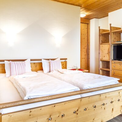 Double bedroom in the Farmhouse, equipped with solid wood furniture and a TV.