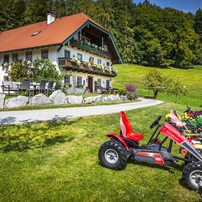 The Ferienwohnung with traditional architecture, balconies, and pedal go-karts available for guests on the property.