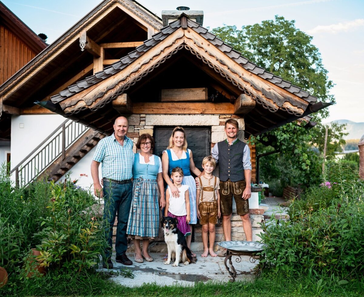The family hosts of the Farm House, including children and a dog, are pictured outside the traditional building.