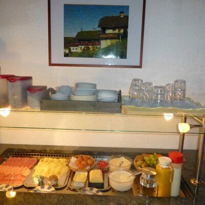 Breakfast buffet at the Ferienwohnung featuring cold cuts, cheese, eggs, cereals, yogurt, fruit, and beverages.