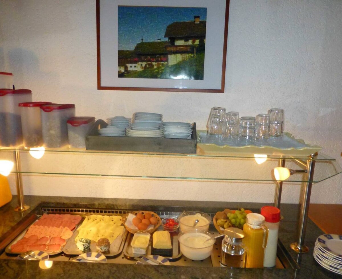 Breakfast buffet at the Ferienwohnung featuring cold cuts, cheese, eggs, cereals, yogurt, fruit, and beverages.