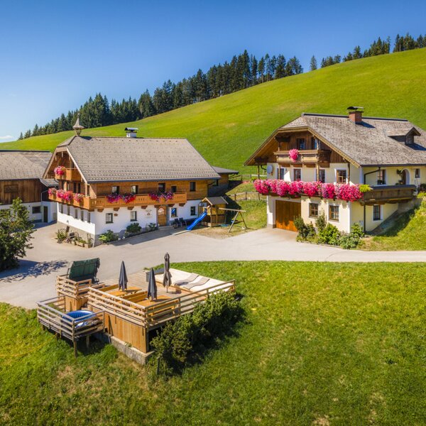 The inviting Ferienwohnung nestled in an idyllic mountain landscape with spacious lawns and a sunny wooden terrace.