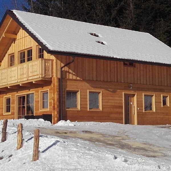 The wooden Farm House features a snow-covered roof and a balcony, set in a snowy landscape with a forest backdrop. The wooden Farm House features a snow-covered roof and a balcony, set in a snowy landscape with a forest backdrop.