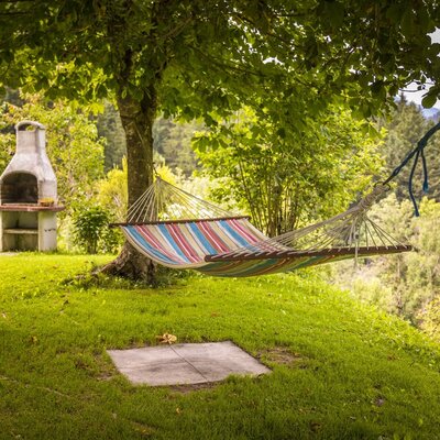 The farmhouse garden features a striped hammock and a barbecue grill for guests.