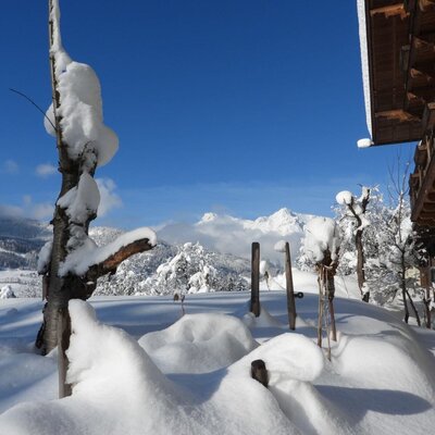 The Farm House exterior in winter, featuring deep snow and mountain views.