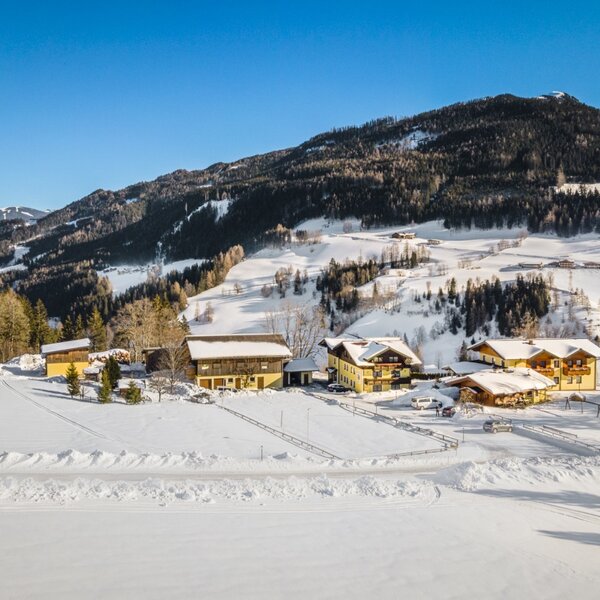 The Farm House buildings are set in a snow-covered mountain landscape. The Farm House buildings are set in a snow-covered mountain landscape.