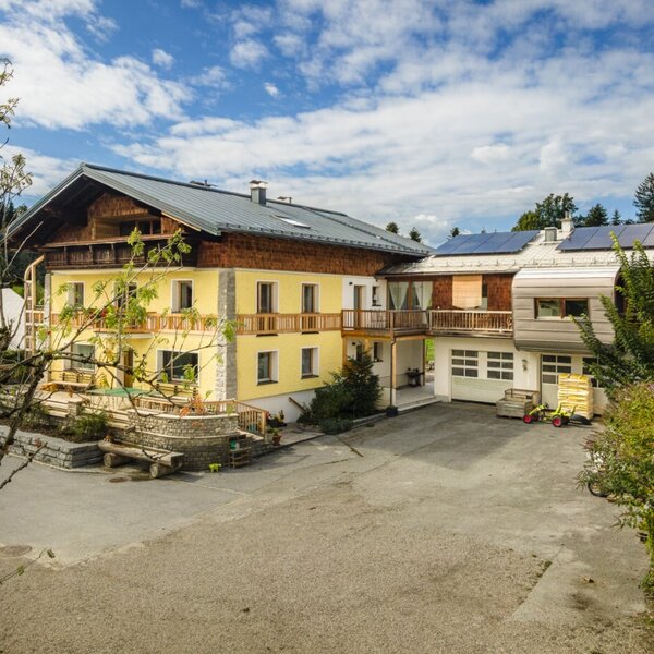 The inviting farmhouse in a sunny location, surrounded by lush nature and a spacious courtyard.