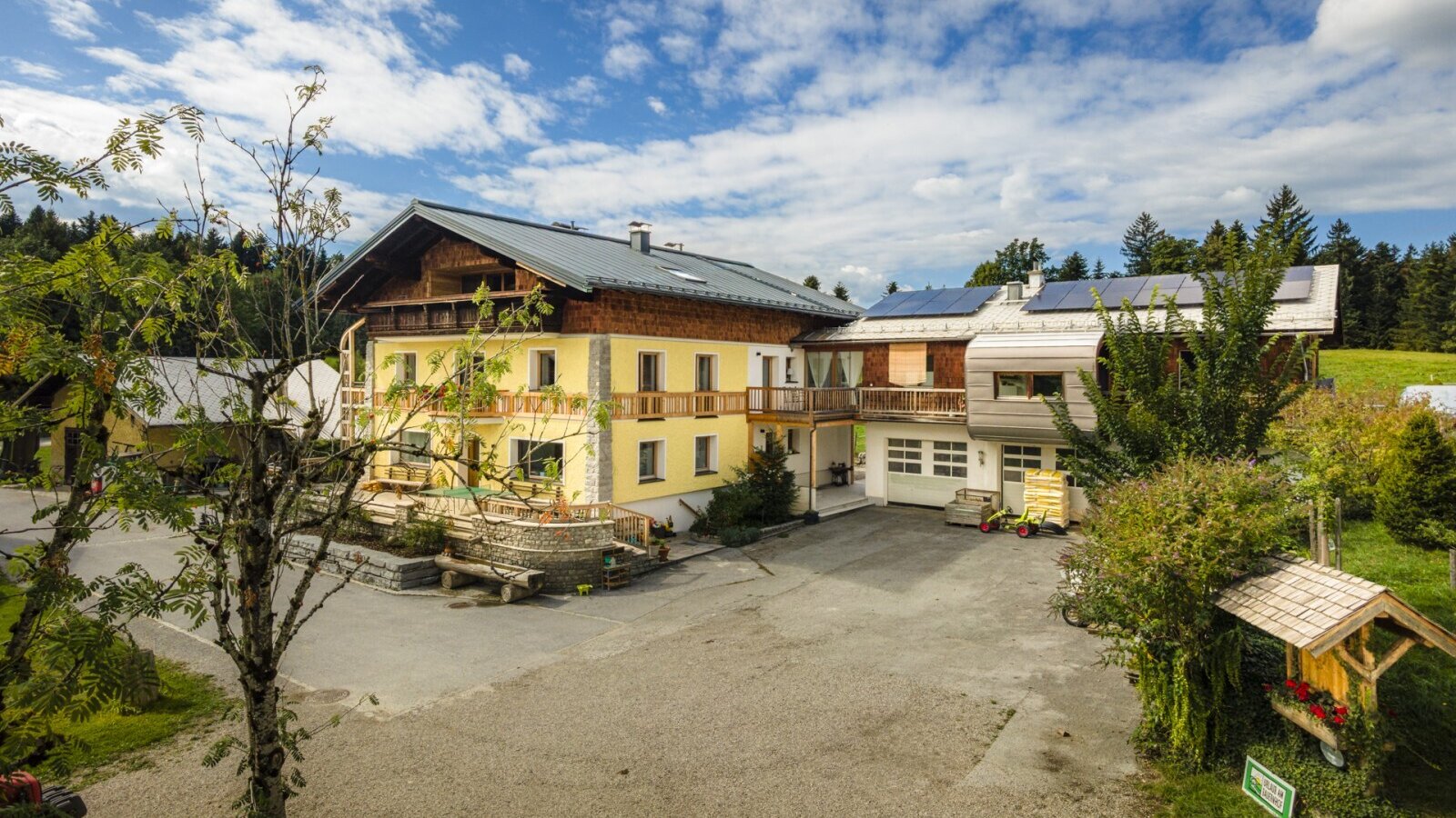 The inviting farmhouse in a sunny location, surrounded by lush nature and a spacious courtyard.