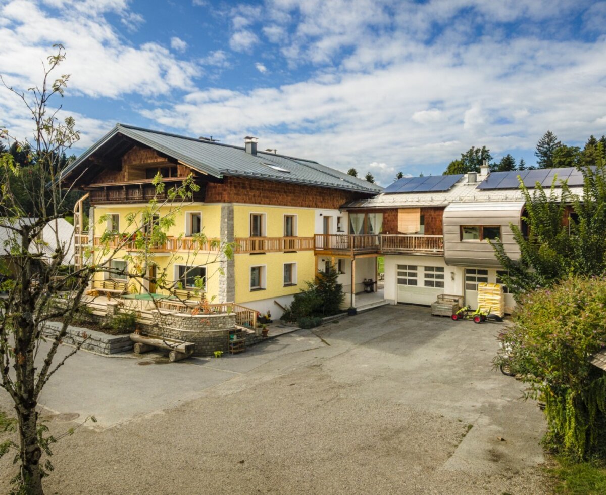 The inviting farmhouse in a sunny location, surrounded by lush nature and a spacious courtyard.