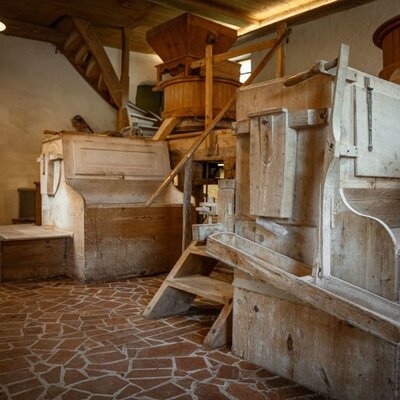 Historic wooden mill machinery within the Bed and Breakfast, featuring stairs and a tiled floor.