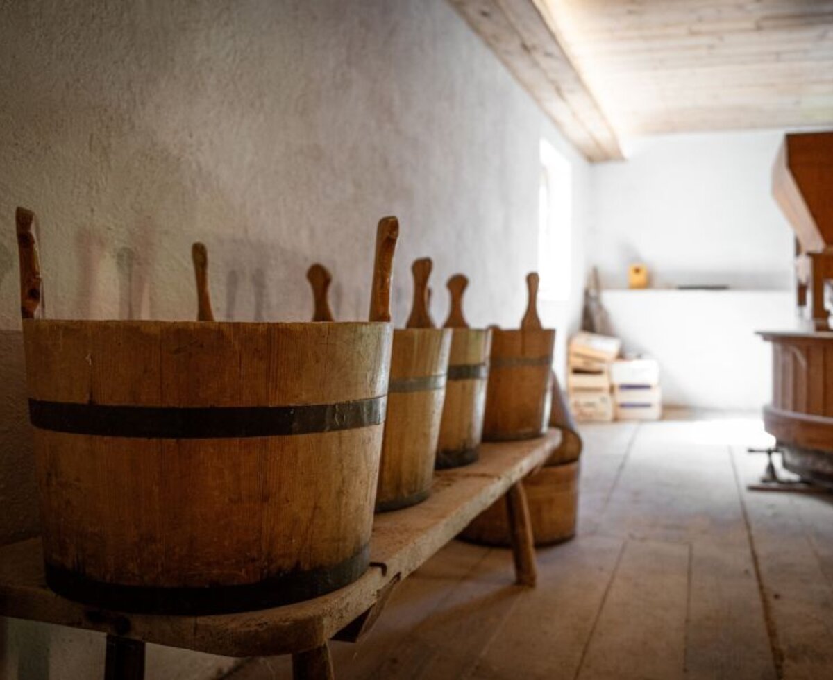 Historical wooden buckets on a wooden bench in a rustic area of the Bed and Breakfast.