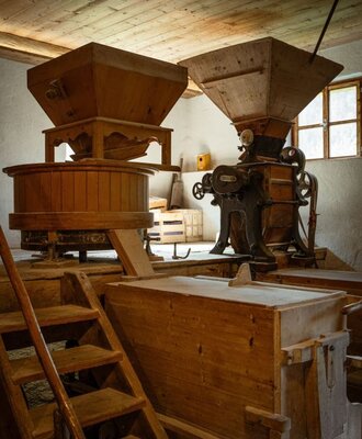 Historic mill machinery with wooden structures and grinding mechanisms at the Bed and Breakfast.
