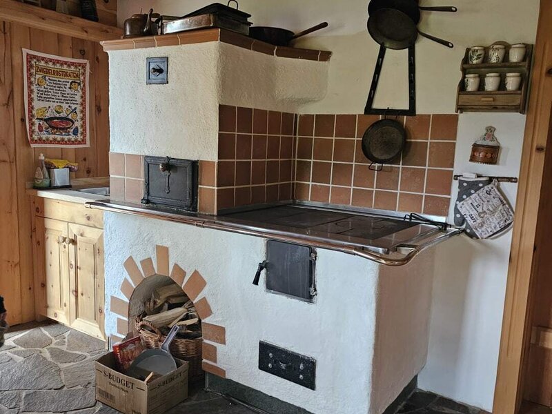 The traditional kitchen of the Bed and Breakfast featuring a wood-burning stove with an oven and a stone floor.