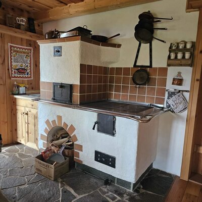 The traditional kitchen of the Bed and Breakfast featuring a wood-burning stove with an oven and a stone floor.