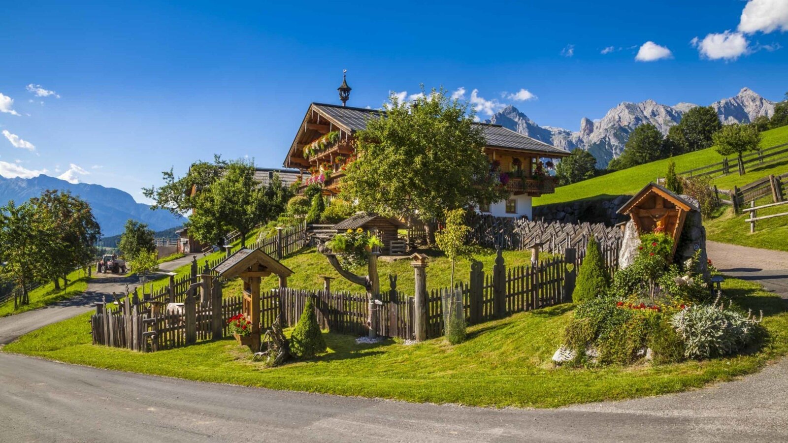 The Farm House exterior, featuring traditional wooden architecture, a landscaped garden, and views of the surrounding mountains.