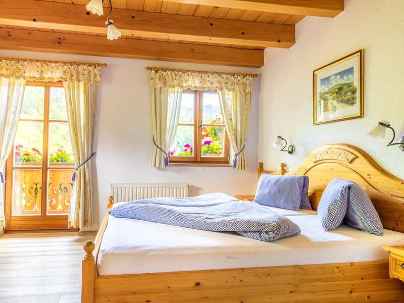 Bright double bedroom in the Farm House, with solid wood furniture and access to a balcony.