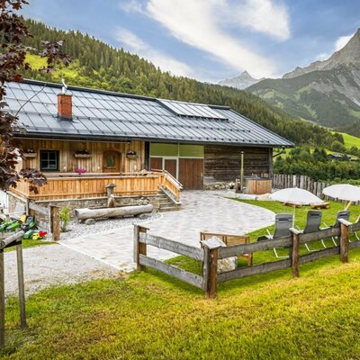 The cozy Almhütte in a peaceful, secluded location featuring a well-kept outdoor area with sun loungers and scenic views of the Hochkönig massif.