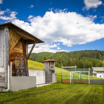 The farm house provides an outdoor climbing wall and a fenced grassy play area with a football goal.
