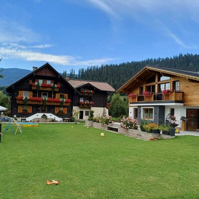 The farmhouse buildings with a large lawn and a children's playground.