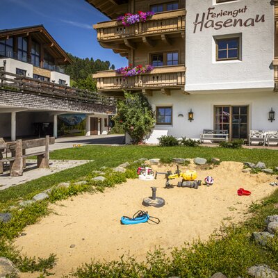 The farm's inviting outdoor area featuring a children's sandbox and a rustic wooden seating area.
