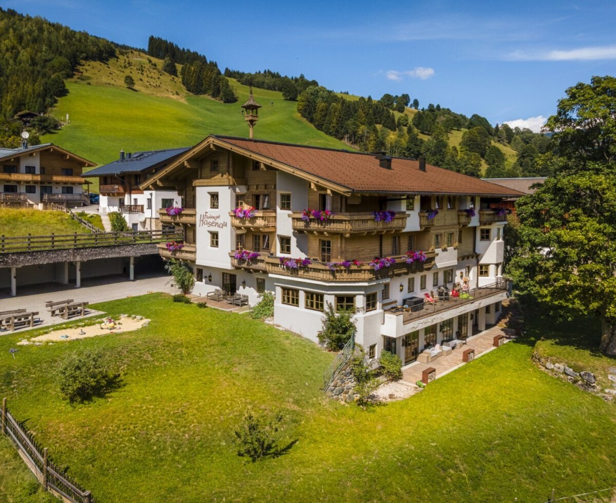 The inviting farmhouse surrounded by green meadows, featuring flower-filled balconies and a spacious garden.