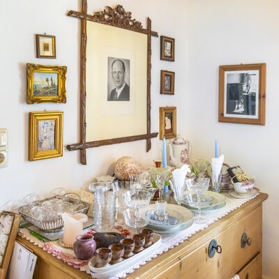 Wooden chest of drawers in the vacation rental, stocked with an assortment of dishes and glassware for guest use.