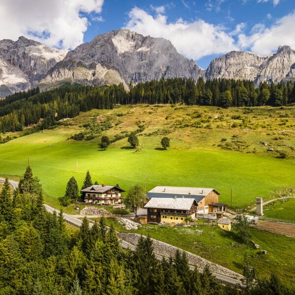The inviting farmhouse surrounded by lush green meadows at the foot of the majestic Hochkönig mountain range.